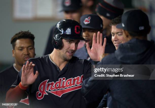 Lonnie Chisenhall of the Cleveland Indians is congratulated in by teammates in the dugout after scoring on a hit by Bradley Zimmer of the Cleveland...