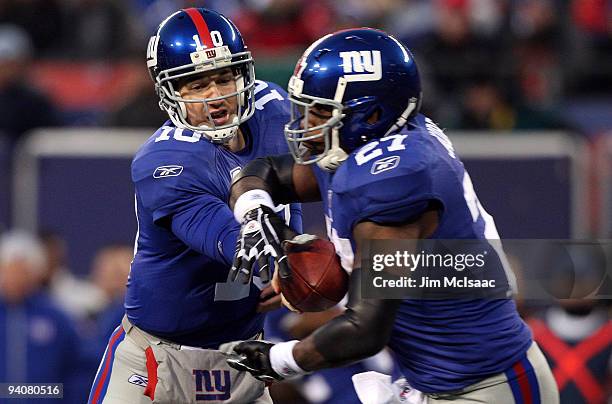 Eli Manning of the New York Giants hands the ball off to Brandon Jacobs against the Dallas Cowboys at Giants Stadium on December 6, 2009 in East...