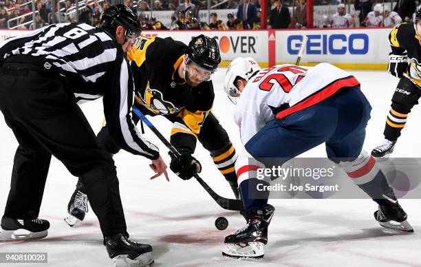 Riley Sheahan of the Pittsburgh Penguins takes a face-off against Lars Eller of the Washington Capitals at PPG Paints Arena on April 1, 2018 in...