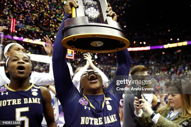 Arike Ogunbowale of the Notre Dame Fighting Irish hoist the NCAA championship trophy after scoring the game winning basket to defeat the Mississippi...