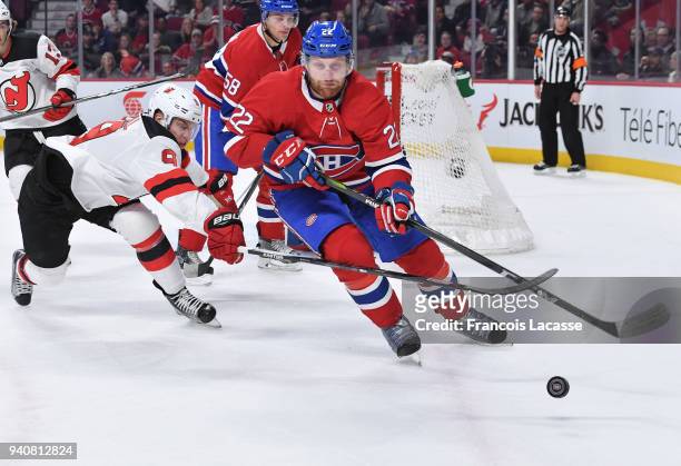 Karl Alzner of the Montreal Canadiens clears the puck against the pressure from Taylor Hall of the New Jersey Devils in the NHL game at the Bell...