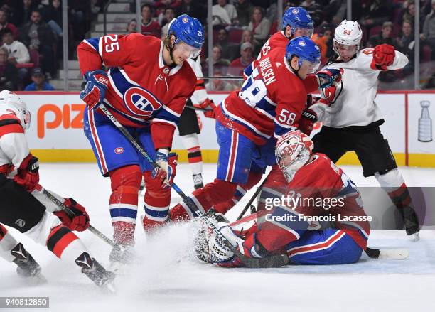 Carey Price of the Montreal Canadiens covers up the puck with help from Jacob De La Rose and Noah Juulsen, and under pressure from Jesper Bratt of...