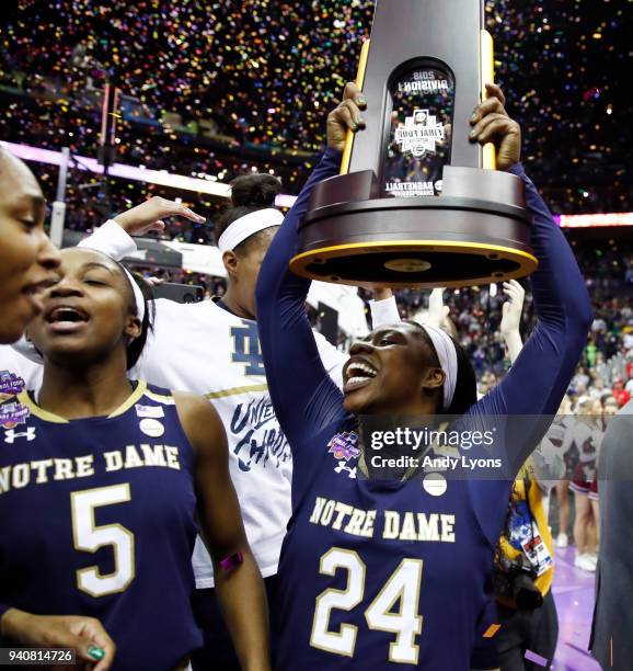 Arike Ogunbowale of the Notre Dame Fighting Irish hoists the NCAA championship trophy after scoring the game winning basket to defeat the Mississippi...