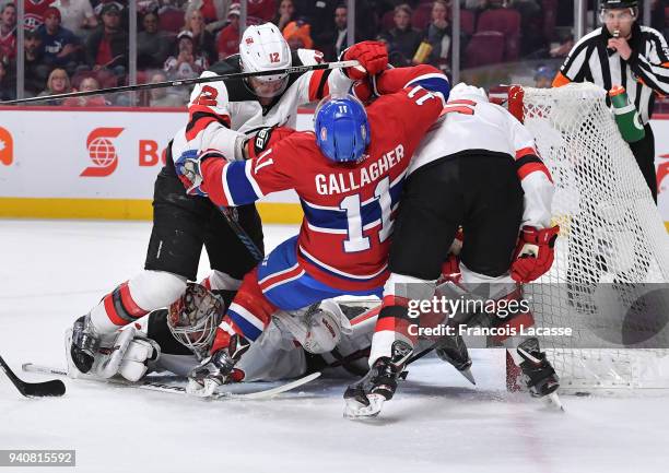 Keith Kinkaid and Ben Lovejoy of the New Jersey Devils defend the goal against Brendan Gallagher of the Montreal Canadiens in the NHL game at the...