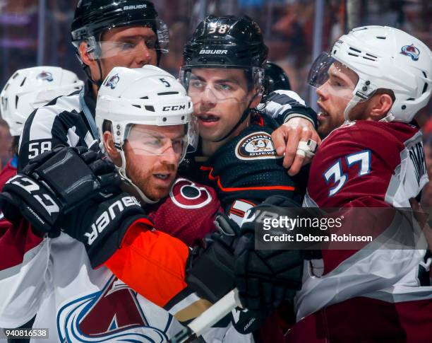 Derek Grant of the Anaheim Ducks is separated from David Warsofsky and J.T. Compher of the Colorado Avalanche by linesman Ryan Gibbons after the...
