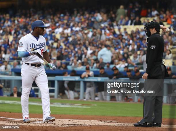 Yasiel Puig of the Los Angeles Dodgers looks to home plate umpire John Tumpane after Puig was called out on strikes to end the first inning during...