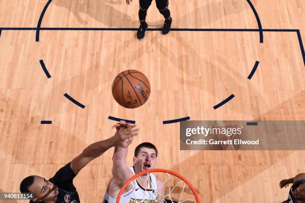 John Henson of the Milwaukee Bucks blocks as Nikola Jokic of the Denver Nuggets goes to shoot on April 1, 2018 at the Pepsi Center in Denver,...