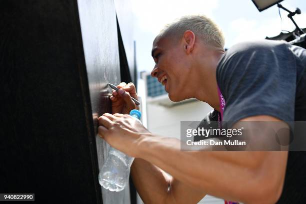 Members of the New Zealand team autograph the NZ sign outside their accomodation in the Athletes Village ahead of the 2018 Commonwealth Games on...