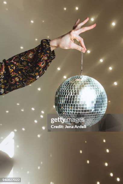 hand holding disco ball retro 1970s - glitter ball stock-fotos und bilder