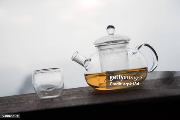 tea in glass teapot on wooden table - theepot stockfoto's en -beelden
