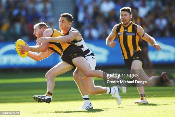 Tom Mitchell of the Hawks is tackled by Joel Selwood of the Cats during the round two AFL match between the Geelong Cats and the Hawthorn Hawks at...