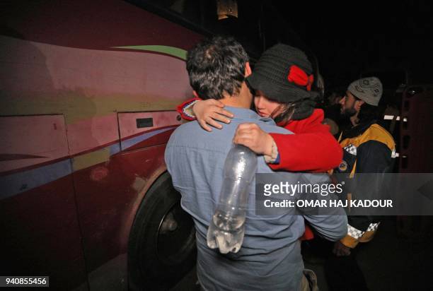Child is carried following their arrival in Qalaat al-Madiq, some 45 kilometres northwest of the central city of Hama, on April 2, 2018 after being...