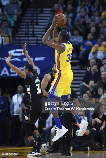 Kevin Durant of the Golden State Warriors shoots over John Henson of the Milwaukee Bucks during an NBA basketball game at ORACLE Arena on March 29,...