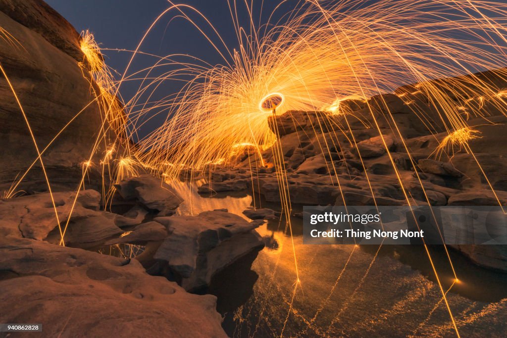 A beautiful spinning steel wool firework in the great canyon in Thailand