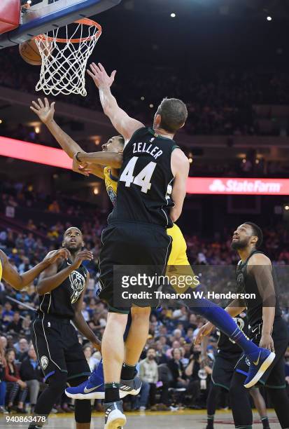 Shaun Livingston of the Golden State Warriors goes in for a layup and gets fouled by Tyler Zeller of the Milwaukee Bucks during an NBA basketball...