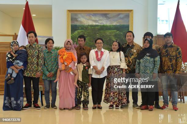 Indonesia's Foreign Minister Retno Marsudi poses with recently released hostages from Libya and their families at a government handover ceremony...