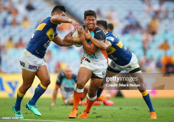 Nolan Stringer Esan Nike Masters of the Tigers is tackled during the round four NRL ...