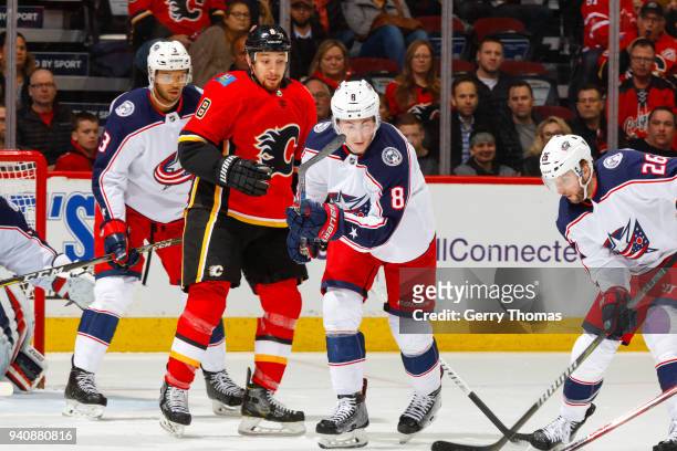 Chris Stewart of the Calgary Flames and Zach Werenski and Thomas Vanek of the Columbus Blue Jackets battle for the puck in an NHL game on March 29,...