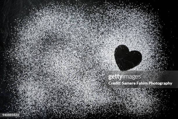 heart shape formed by powdered sugar on slate - poedersuiker stockfoto's en -beelden