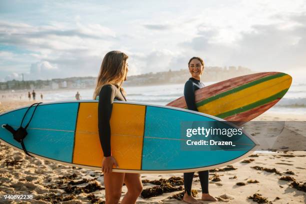 two female friends with surfboards - bondi beach stock pictures, royalty-free photos & images