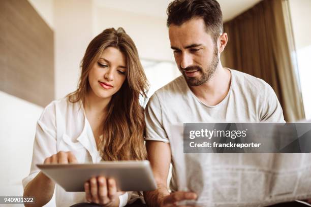 paar, lezen de krant op het hotel - gedrukte media stockfoto's en -beelden