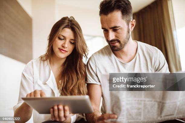 couple reading the newspaper on the hotel - confort at hotel bedroom stock pictures, royalty-free photos & images