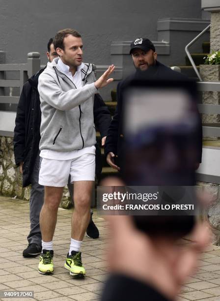 French president Emmanuel Macron waves at wellwishers as he leaves his villa for a sport session, on April 2, 2018 in Le Touquet, where he spends the...