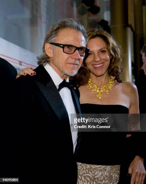 Harvey Keitel and Daphna Kastner pose for photographer on the red carpet before the 32nd Kennedy Center Honors at Kennedy Center Hall of States on...