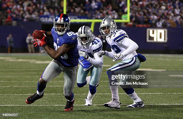 Hakeem Nicks of the New York Giants scores on a 21-yard touchdown reception in the second quarter against Terence Newman and Orlando Scandrick of the...