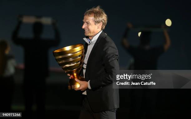 Jurgen Klinsmann carries the French League Cup before the start of the French League Cup final between Paris Saint-Germain and AS Monaco on March 31,...