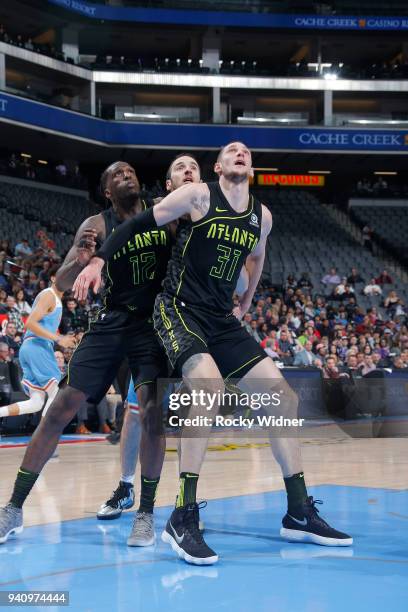 Mike Muscala and Taurean Prince of the Atlanta Hawks box out Kosta Koufos of the Sacramento Kings on March 22, 2018 at Golden 1 Center in Sacramento,...