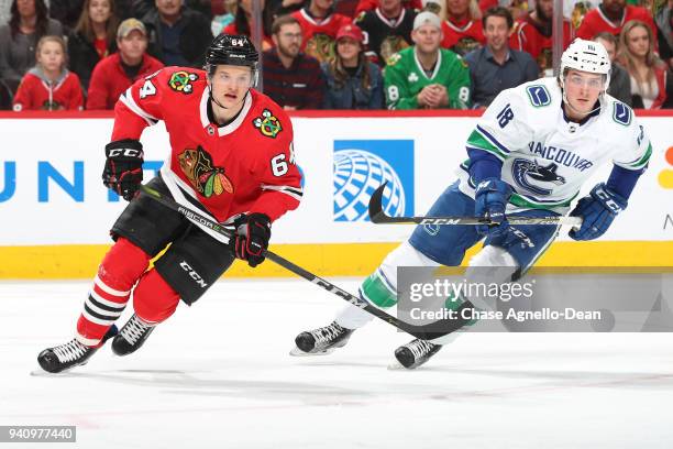 David Kampf of the Chicago Blackhawks and Jake Virtanen of the Vancouver Canucks watch for the puck in the first period at the United Center on March...