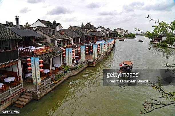 sampan being rowed through zhujiajiao water town, shanghai - zhujiajiao stock pictures, royalty-free photos & images