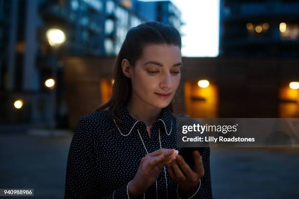 woman using mobile phone at night - lilly roadstones stock pictures, royalty-free photos & images