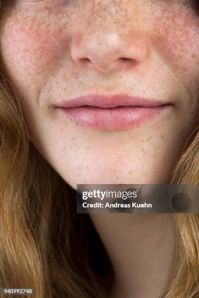 close up shot of a sixteen year old teenage girl with freckles, pale skin and a soft smile cropped below her eyes. - smile close up stock-fotos und bilder