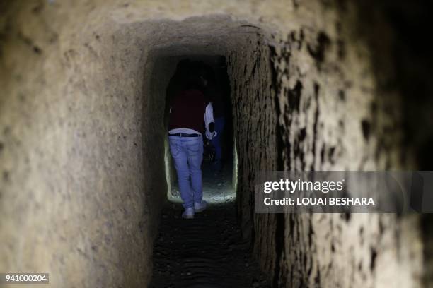 Syrian journalist walks inside a tunnel previously used by rebel-fighter for smuggling goods and taking shelter, in Jobar in Eastern Ghouta on April...