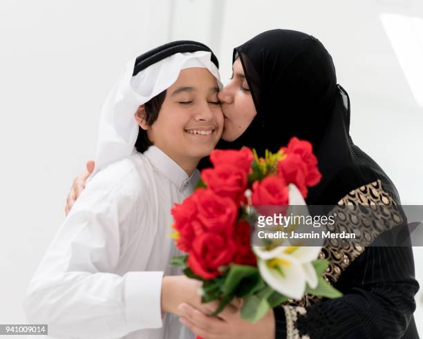 son handing gift to mother - beautiful arabian girls stock pictures, royalty-free photos & images