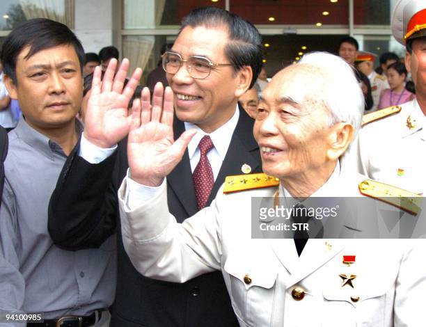 General Vo Nguyen Giap and Party Chief Nong Duc Manh wave prior to a meeting celebrating the 50th anniversary of Dien Bien Phu victory in Hanoi, 05...