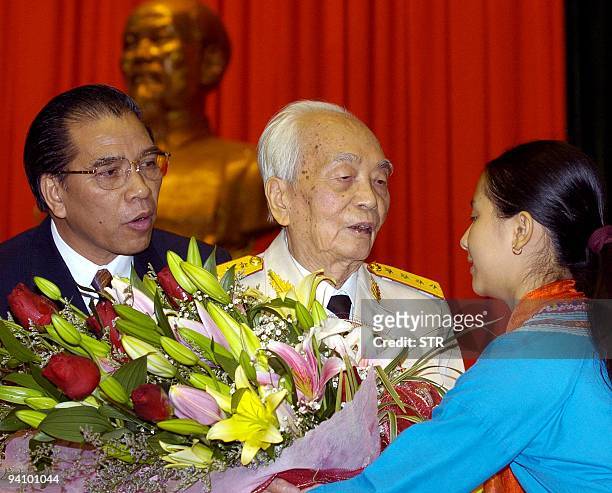 Vietnamese legendary retired 94-year-old General Vo Nguyen Giap is greeted with flowers after addressing a meeting held 20 December 2004 in Hanoi to...