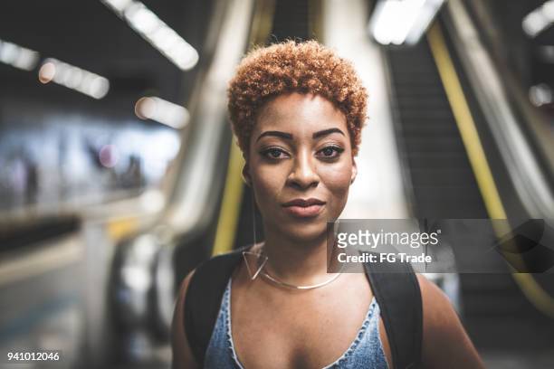 afro junge frau porträt in metro-station - dyed red hair stock-fotos und bilder