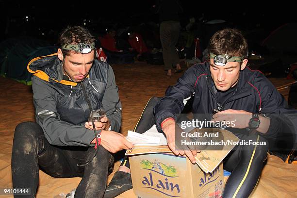 Marc Pschebizin of Germany and Benjamin Rossmann of Germany study the map of the next stage on December 5, 2009 in Abu Dhabi, United Arab Emirates.