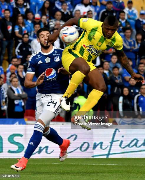 Matias de los Santos of Millonarios competes for the ball with Marlon Torres of Atletico Bucaramanga during a 12th round match between Millonarios...