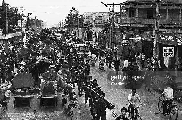 April 1975 photo shows jubilant communist troops on top of trucks and APCs making their way to the centre of Saigon as the city fell under their...