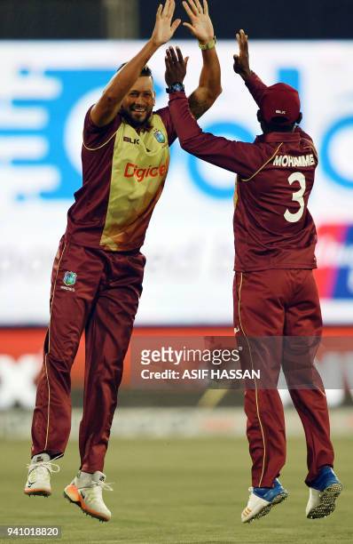 West Indies bower Rayad Emrit celebrates with team captain Jason Mohammed after taking the wicket of Pakistani batsman Fakhar Zaman during the second...