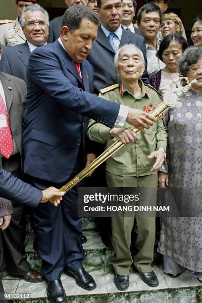 Visiting Venezuelean President Hugo Chavez hands over a sword similar to that one used by Venezuela's hero Simon Bolivar to Vietnamese legendary...