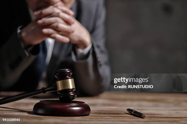 close-up of lawyer sitting at table - sentenciar fotografías e imágenes de stock