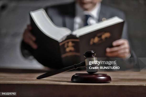 lawyer reading law book at desk - juge photos et images de collection