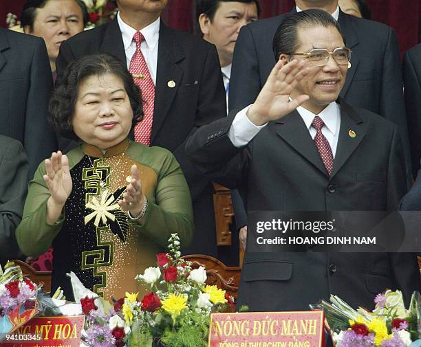 Vietnamese Communist Party's Secretary General Nong Duc Manh and Vice-President Truong My Hoa waves and claps as they watch a military parade during...