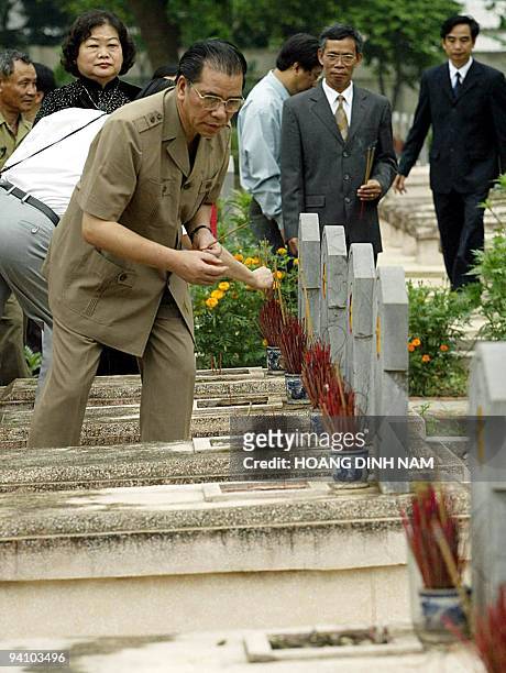Vietnamese Communist Party's Secretary General Nong Duc Manh places incense sticks on the graves of Vietnamese soldiers killed during Dien Bien Phu...