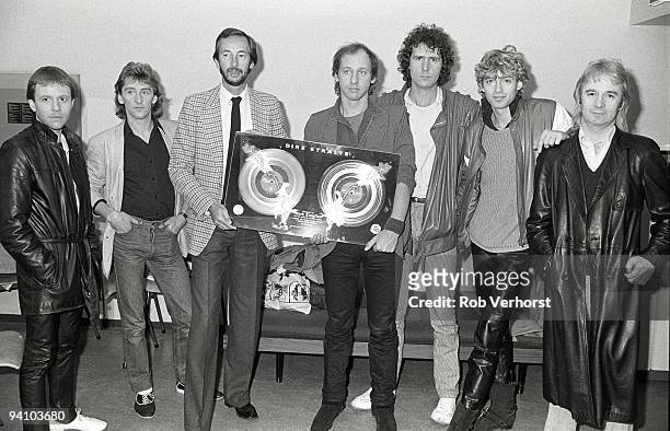 Dire Straits are presented with a gold disc awarded for sales of more than 100,000 albums of Love Over Gold within 2 weeks of release in Holland. L-R...
